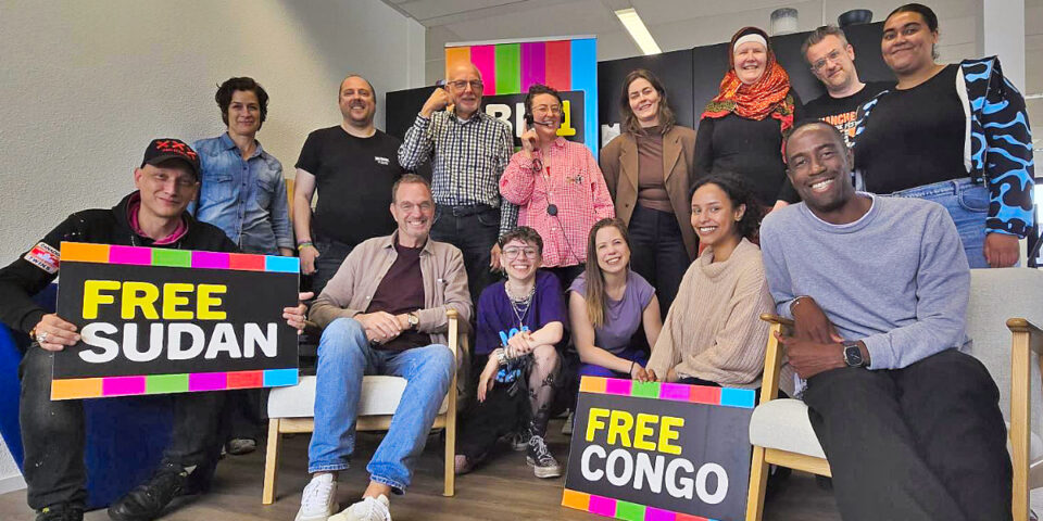 Groepsfoto van lachende groep diverse mensen op kantoor bij BIJ1